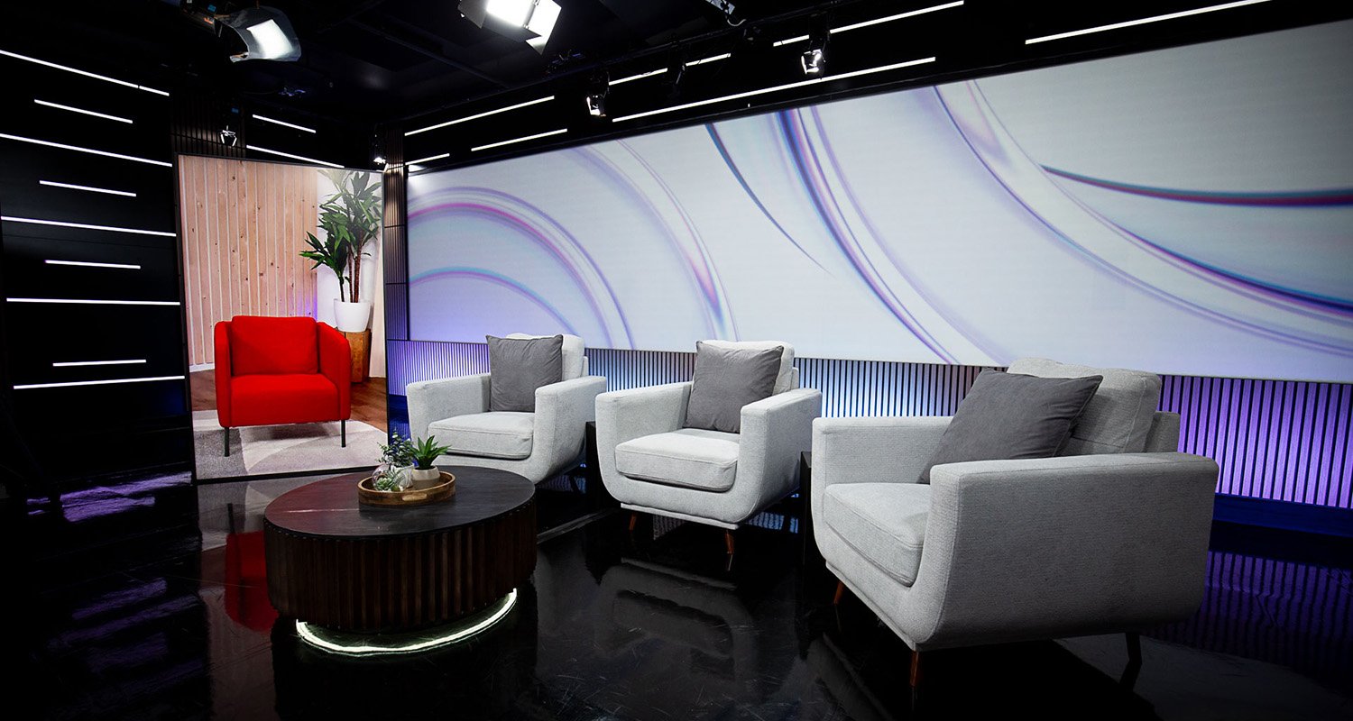 Studio Notre-Dame aménagé en configuration salon avec écran LED pour une émission ou une discussion en panel.