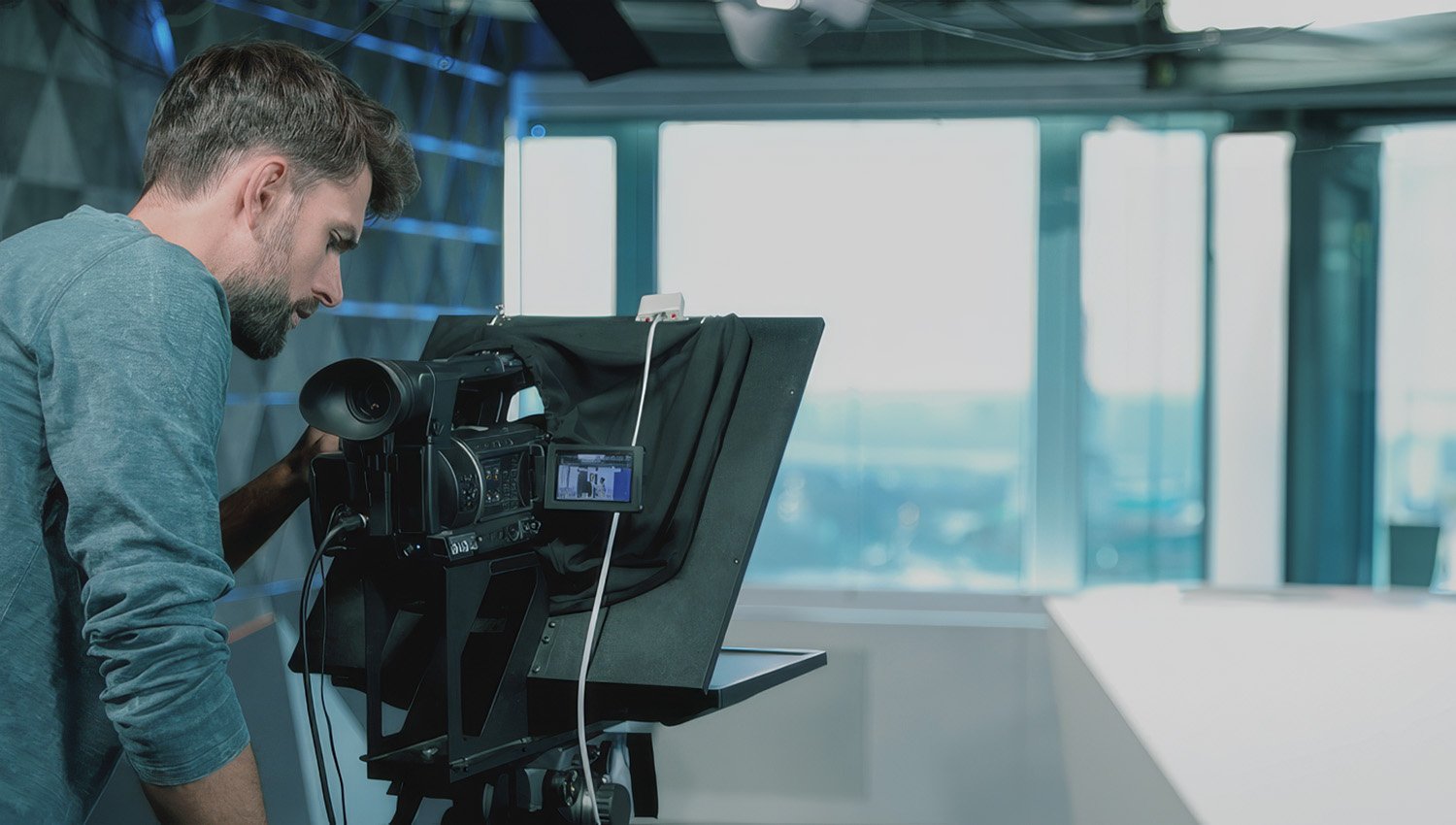 Camera operator filming professional video content in a corporate studio.